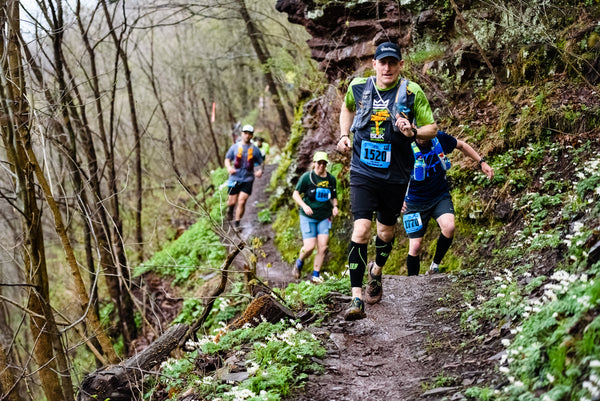 group of people trail running in the woods